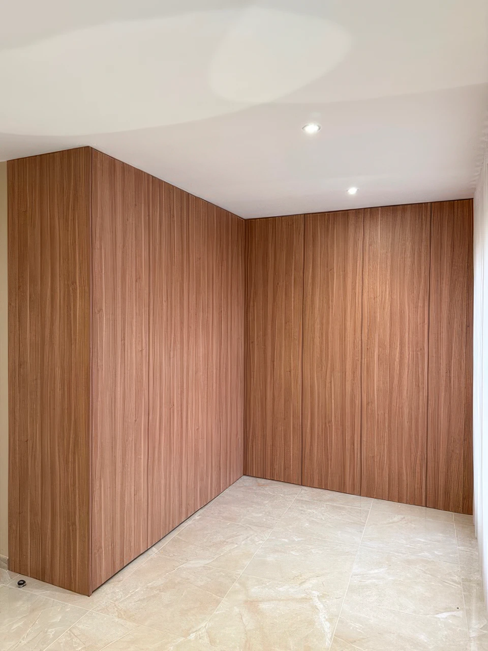 Salon parisien avec bibliothèque sur mesure en bois clair intégrée au mur, chargée de livres multicolores, avec téléviseur Sony encastré