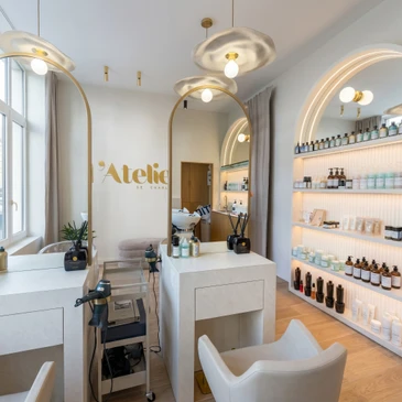 Int&eacute;rieur d'un espace retail de luxe mettant en sc&egrave;ne un agencement commercial haut de gamme&nbsp;: fa&ccedil;ade en bois noble poli avec panneaux et &eacute;tag&egrave;res int&eacute;gr&eacute;es pr&eacute;sentant des produits de prestige, comptoir en mat&eacute;riaux nobles, ambiance lumineuse et &eacute;pur&eacute;e refl&eacute;tant l'expertise en menuiserie sur mesure et les standards du luxe contemporain.