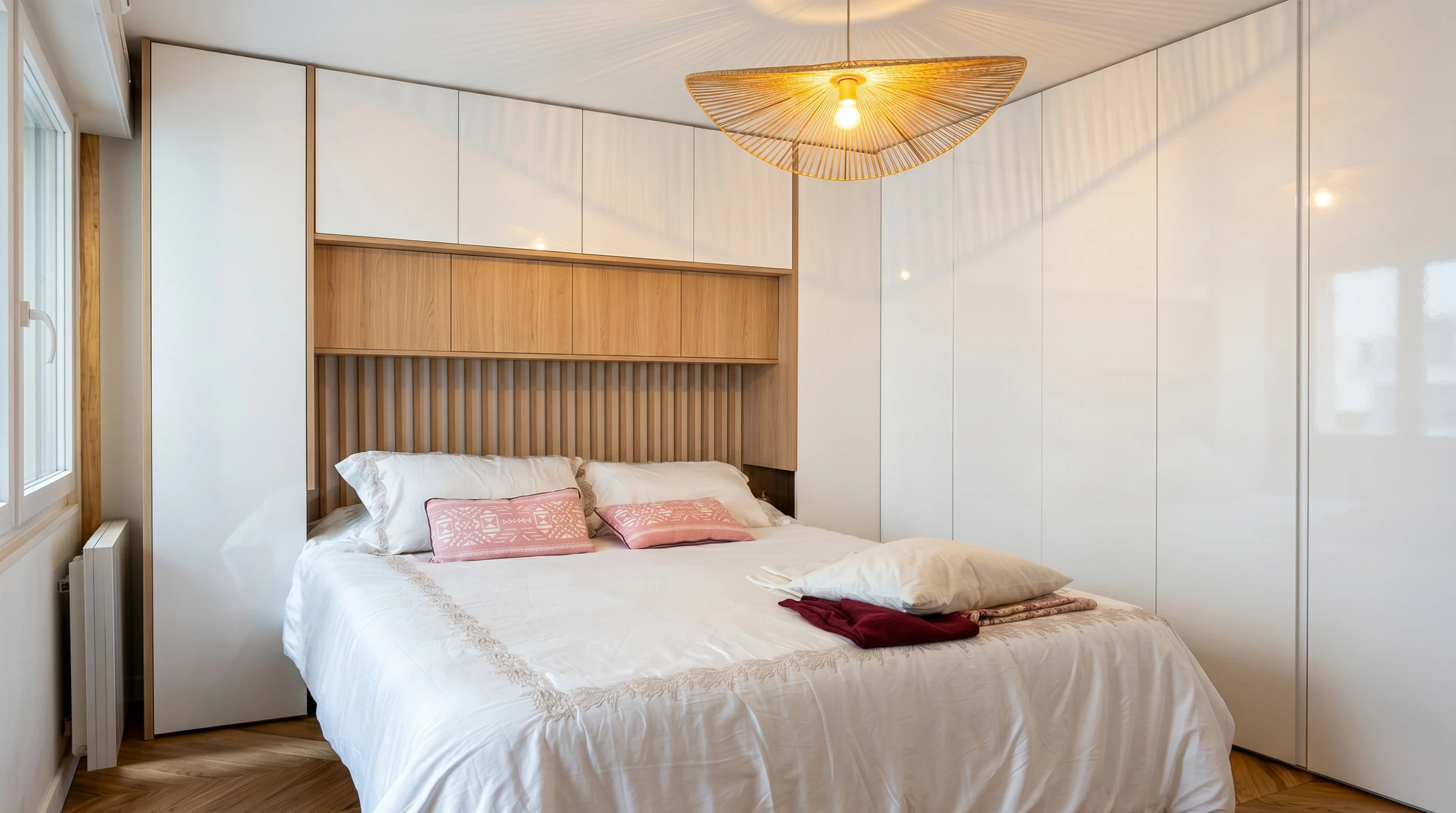 Chambre à la sortie d'une chambre avec portes coulissantes intégrées au mur, parquet rougeâtre et armoires en bois blanc