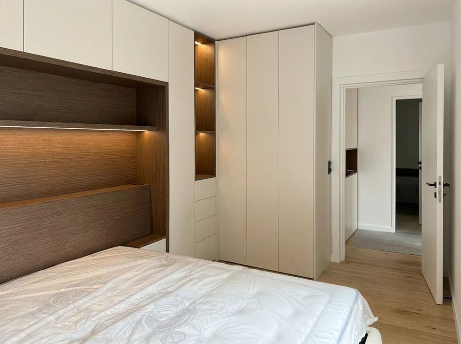 Chambre moderne avec un mur de placards intégrés en placage de noyer américain, finition naturelle mate