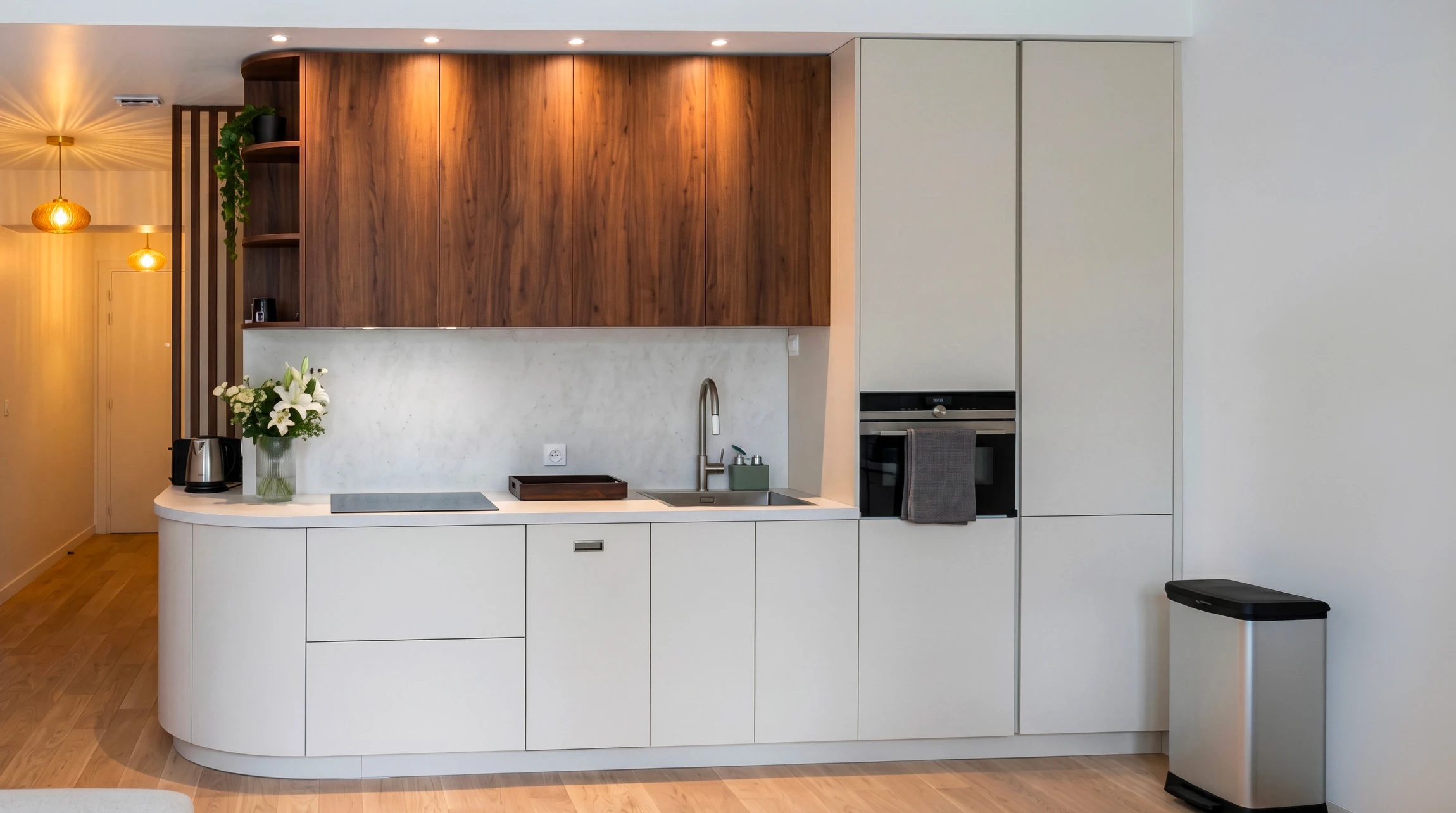 Cuisine moderne en L avec îlot, meubles bas en bois clair et plan de travail noir